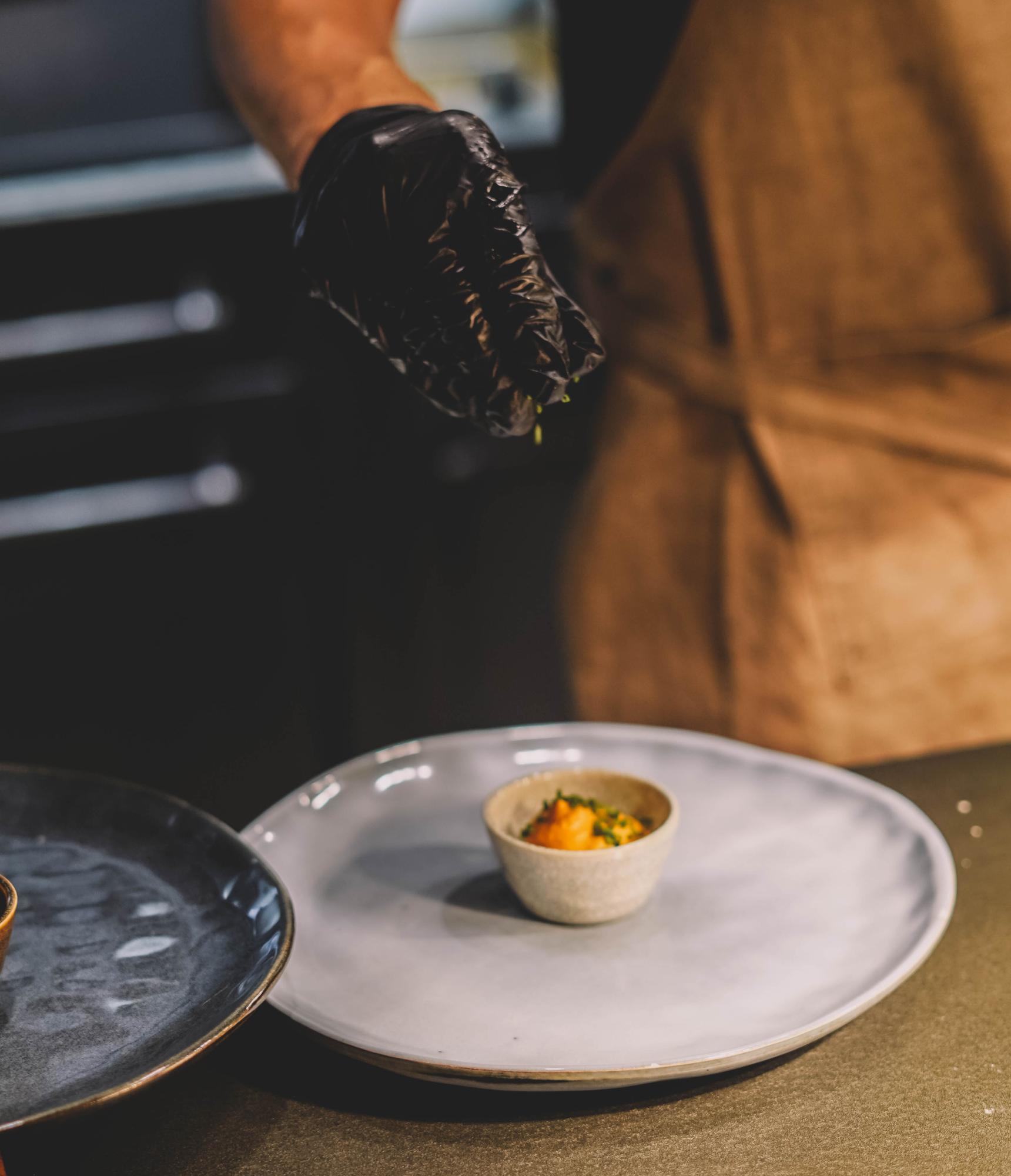 chef plating a bespoke dish on ceramic